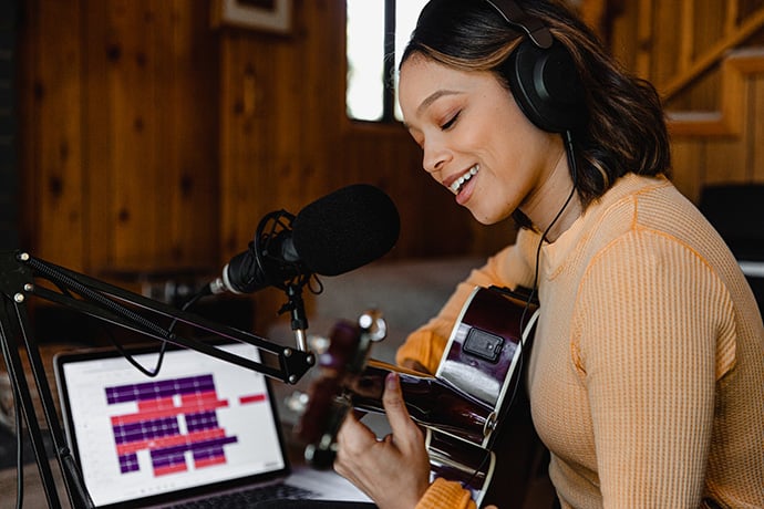 singer recording song on laptop